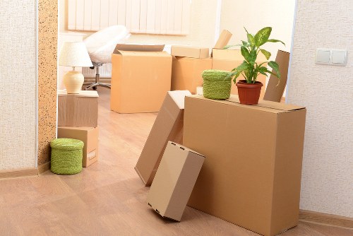 Local movers handling boxes in a narrow Camdentown property stairwell